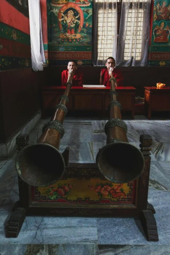 a couple of old - fashioned bells on a stand in a church
