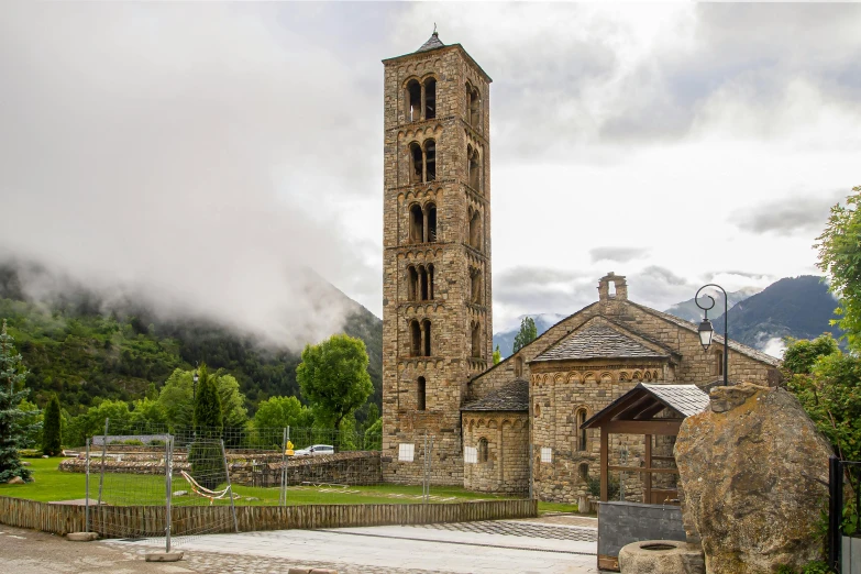 a tall clock tower in front of a stone building