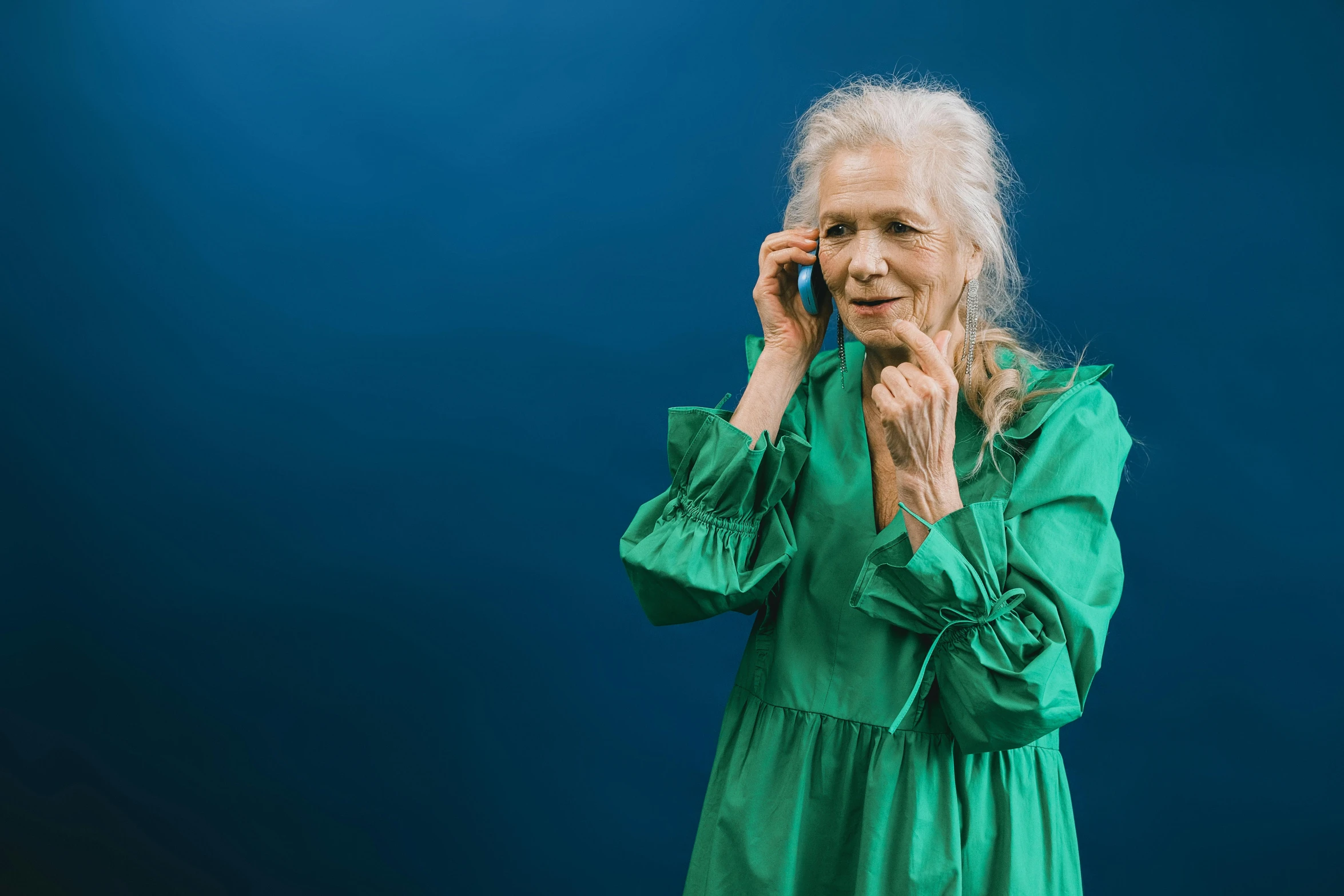 an old woman with white hair is talking on her phone