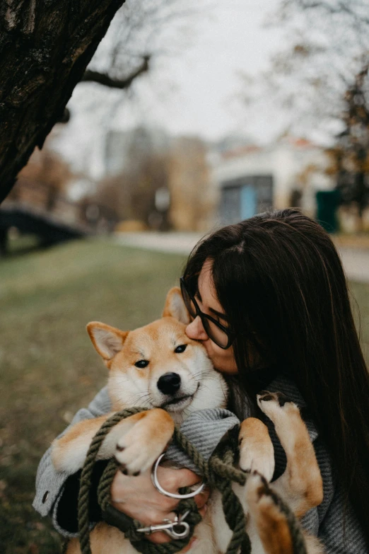 a woman holds two puppies in her arms