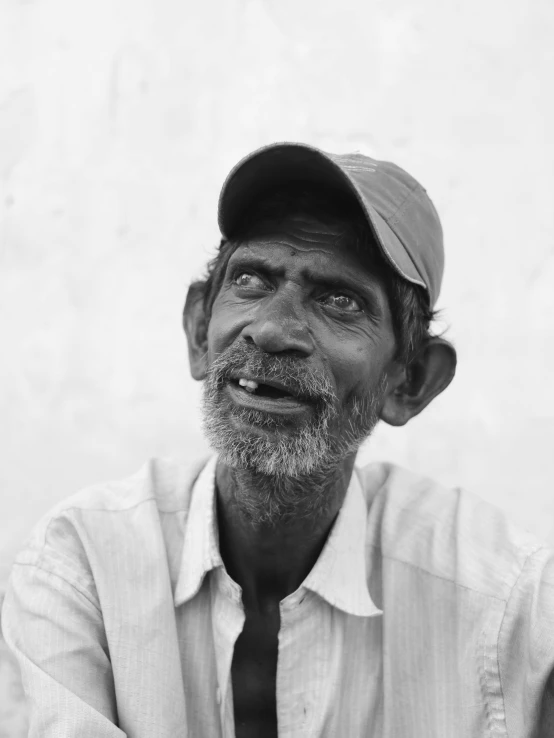 a man with a hat and tie in front of a wall