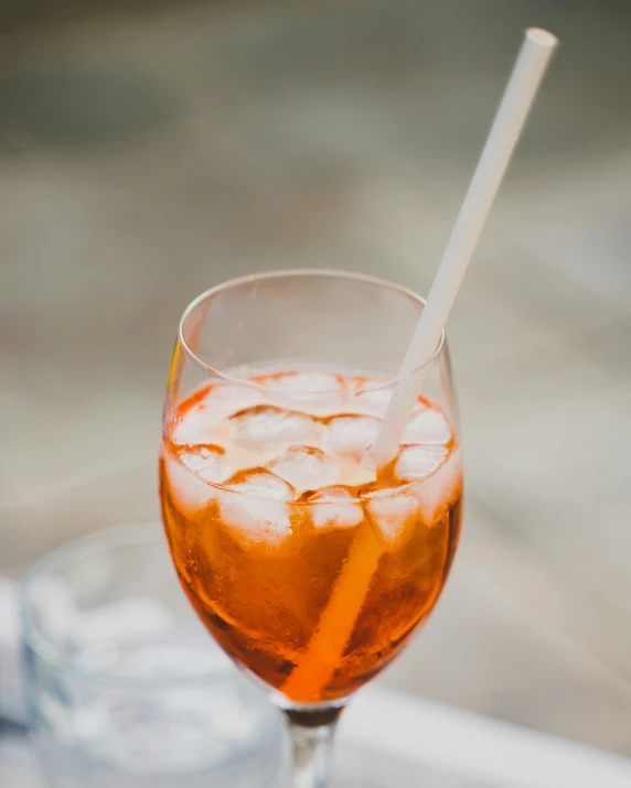 a small glass with liquid in it and a white straw sticking out of the glass