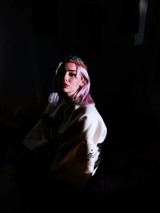 a woman with bright pink hair in a dark room