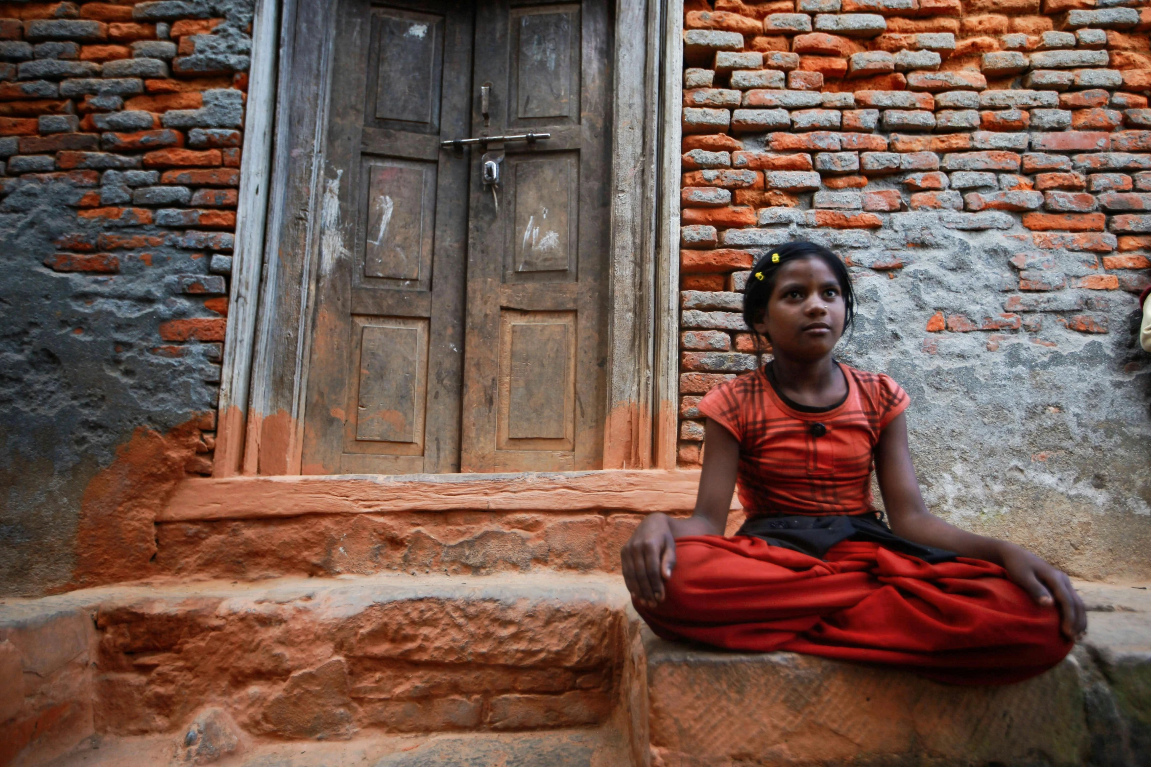 an indian woman sitting in front of an open doorway