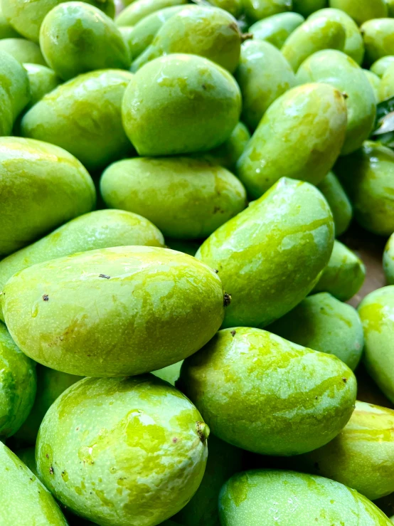 several green fruits piled on top of each other