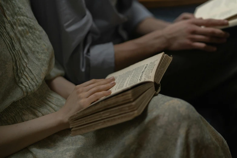 two people reading books sitting down in chairs