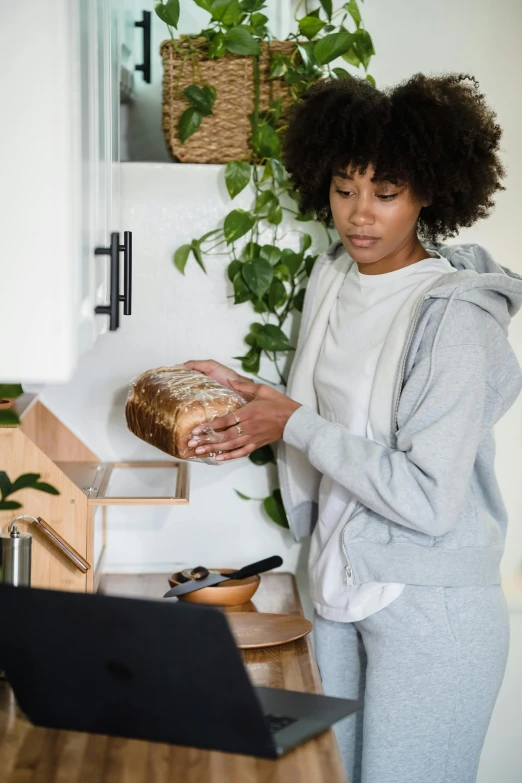 a woman holding soing on the table near a basket of bread