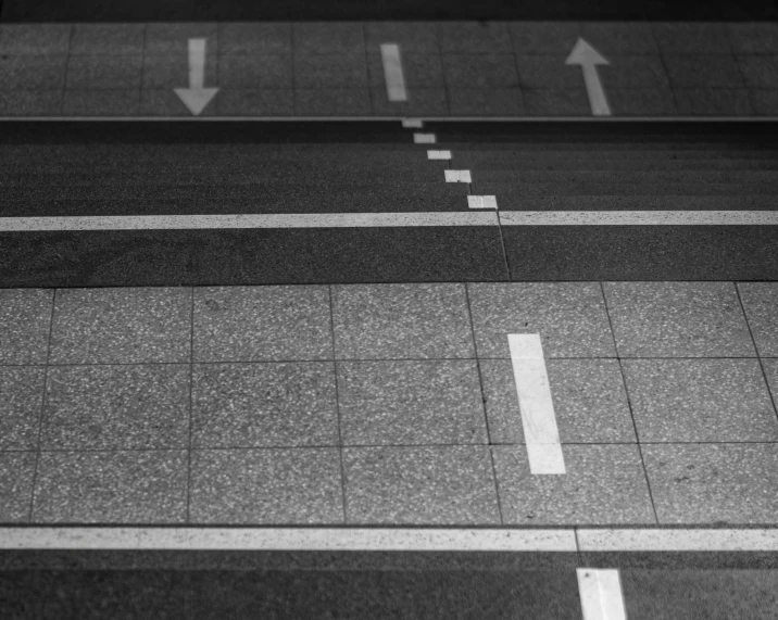 an overhead view of an empty street with arrows