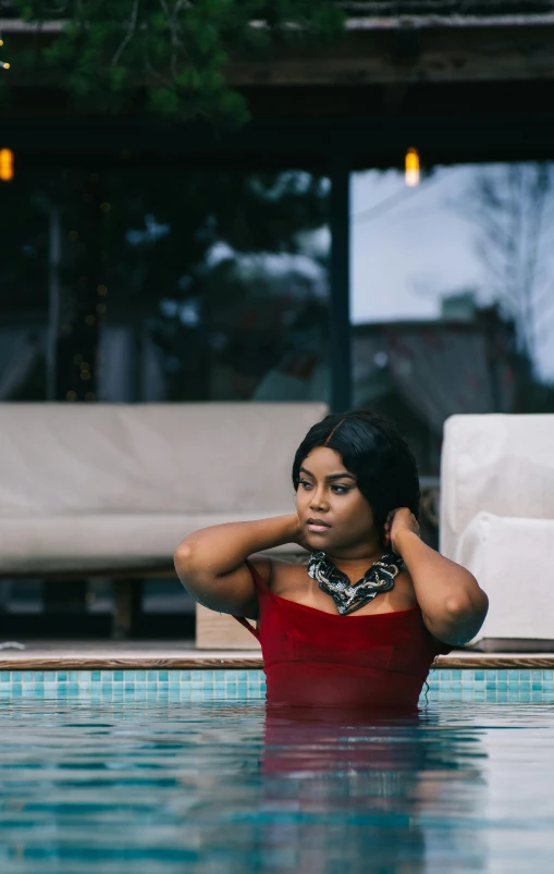 a young woman sitting in the water of a swimming pool