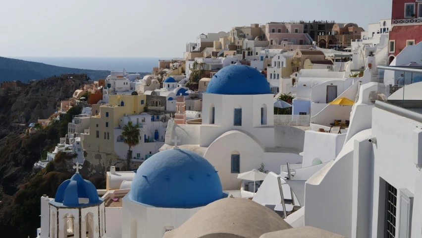 a mountain landscape shows colorful and elaborate buildings with blue domes on them