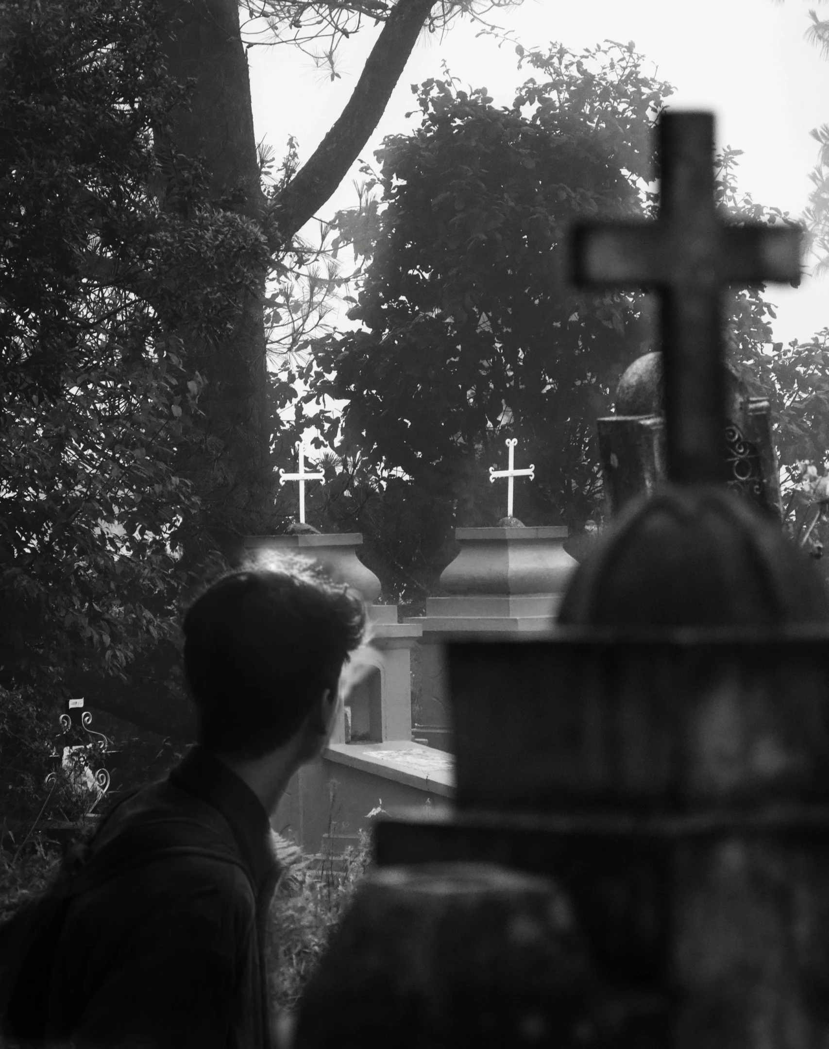 black and white pograph of two men praying at cemetery