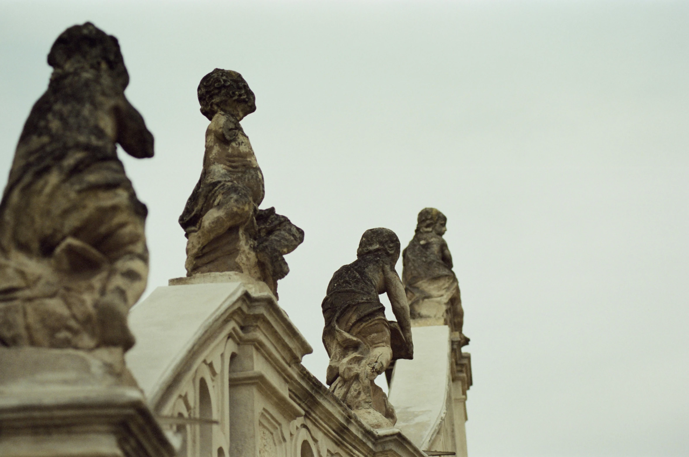 several sculptures are displayed on top of a large building