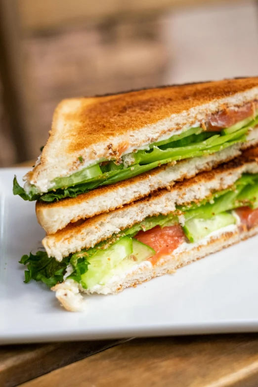 two pieces of sandwich sit on a plate with a beverage