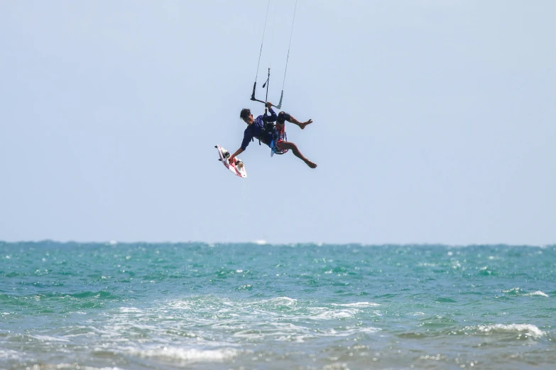 two people kiteboarding over an open body of water