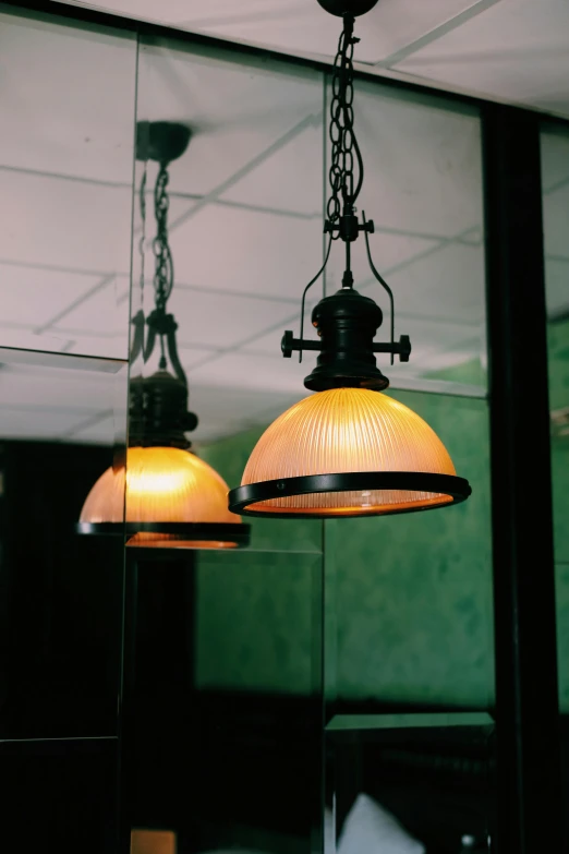 a couple of yellow lights hanging from a ceiling