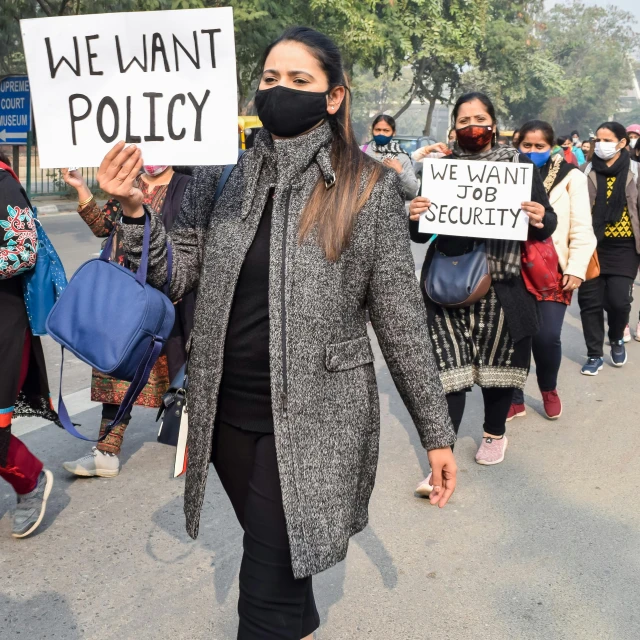 a group of people marching down the street with signs on their face