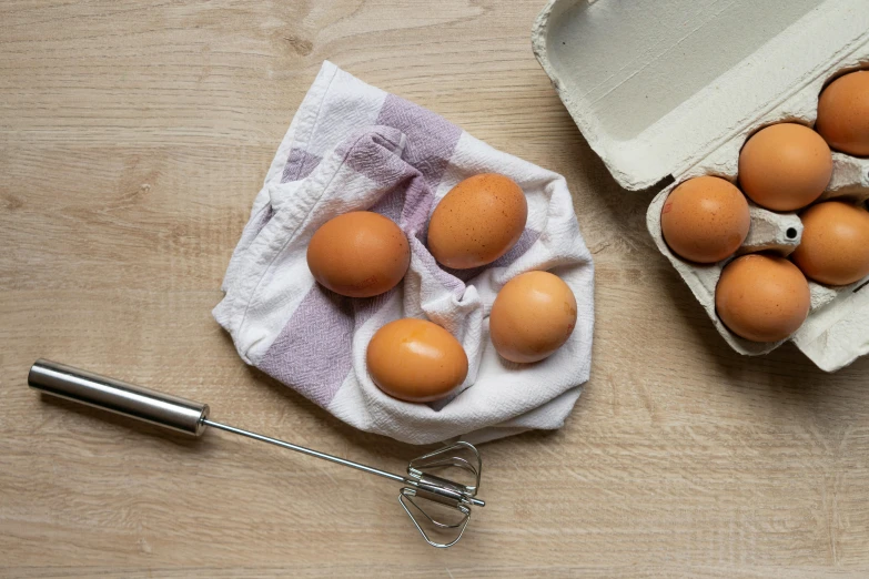 a pair of eggs with one broken egg on a towel