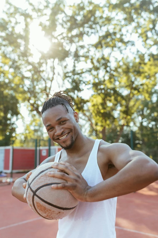 a man holding a basketball on top of a court