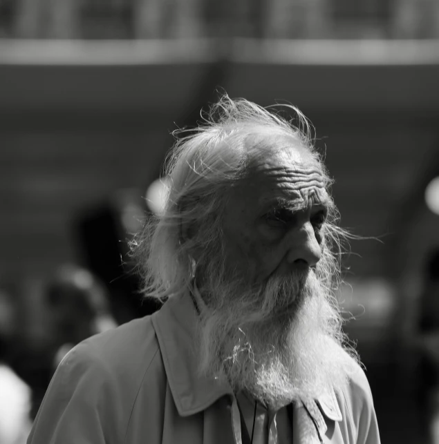 an old man with a beard looks at soing