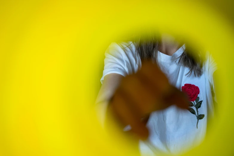 a woman is wearing white and has red roses in her shirt