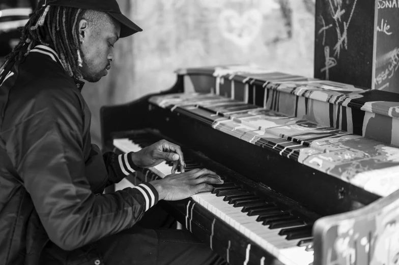 a man sits and plays the organ in front of many records