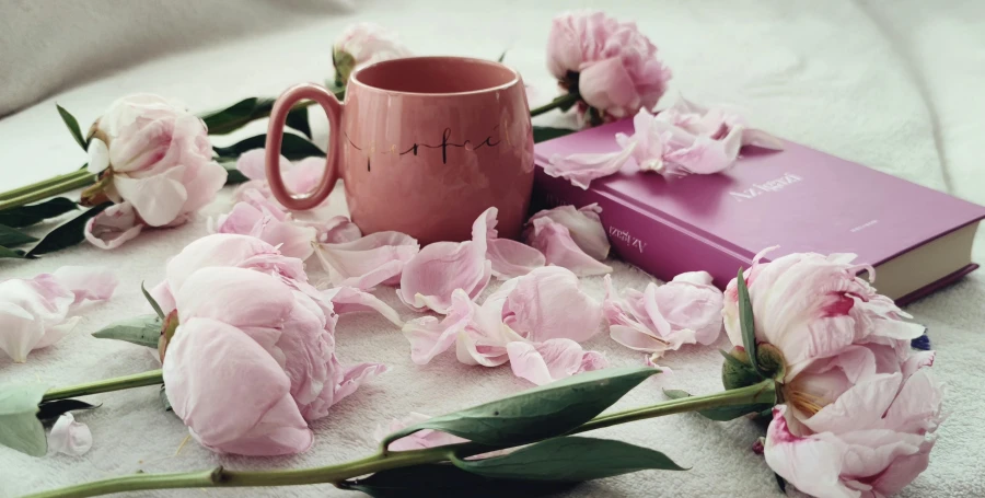 flowers and a coffee cup on a blanket