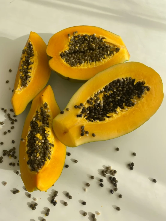 a cut in half papaya with seeds on a white plate