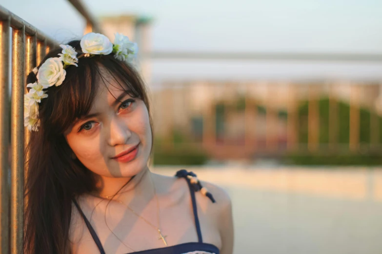 the young asian girl is posing behind a metal fence