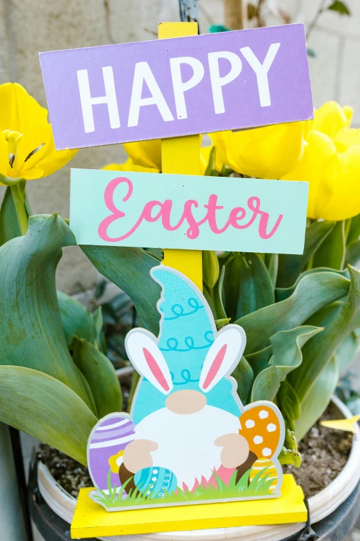 a pot with yellow flowers and a happy easter sign