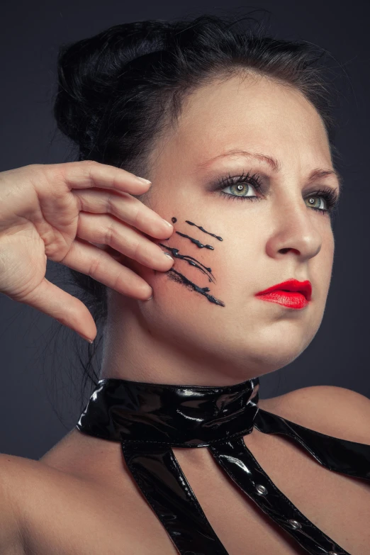 woman with painted face holding up hands wearing black bow tie