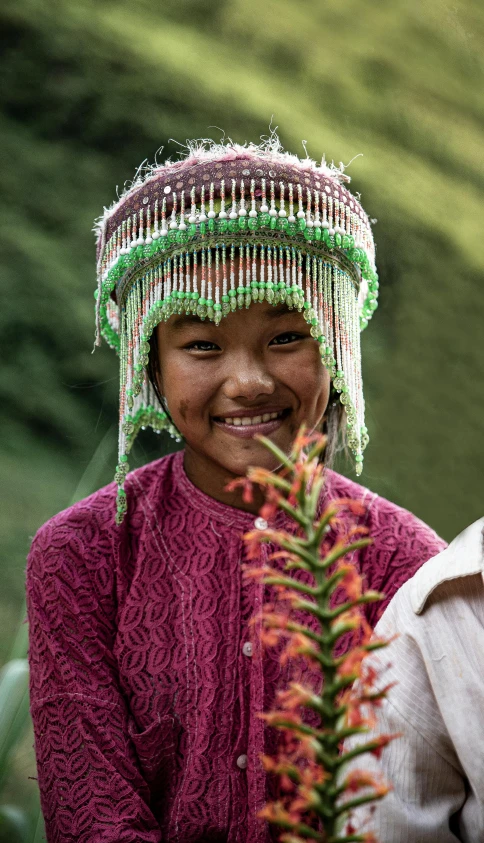 a woman wearing a colorful dress and headdress smiling