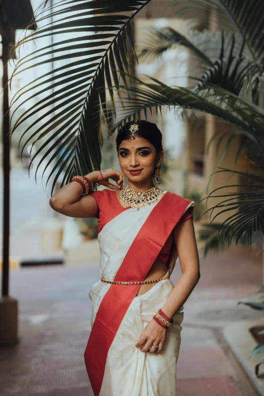 an indian woman dressed in traditional wear posing outside