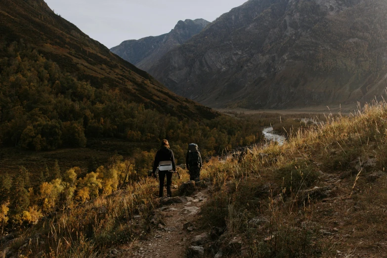 people are walking along a path in a mountainous area