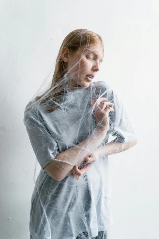 an artistic woman is posing with her eyes closed and the camera in her hand