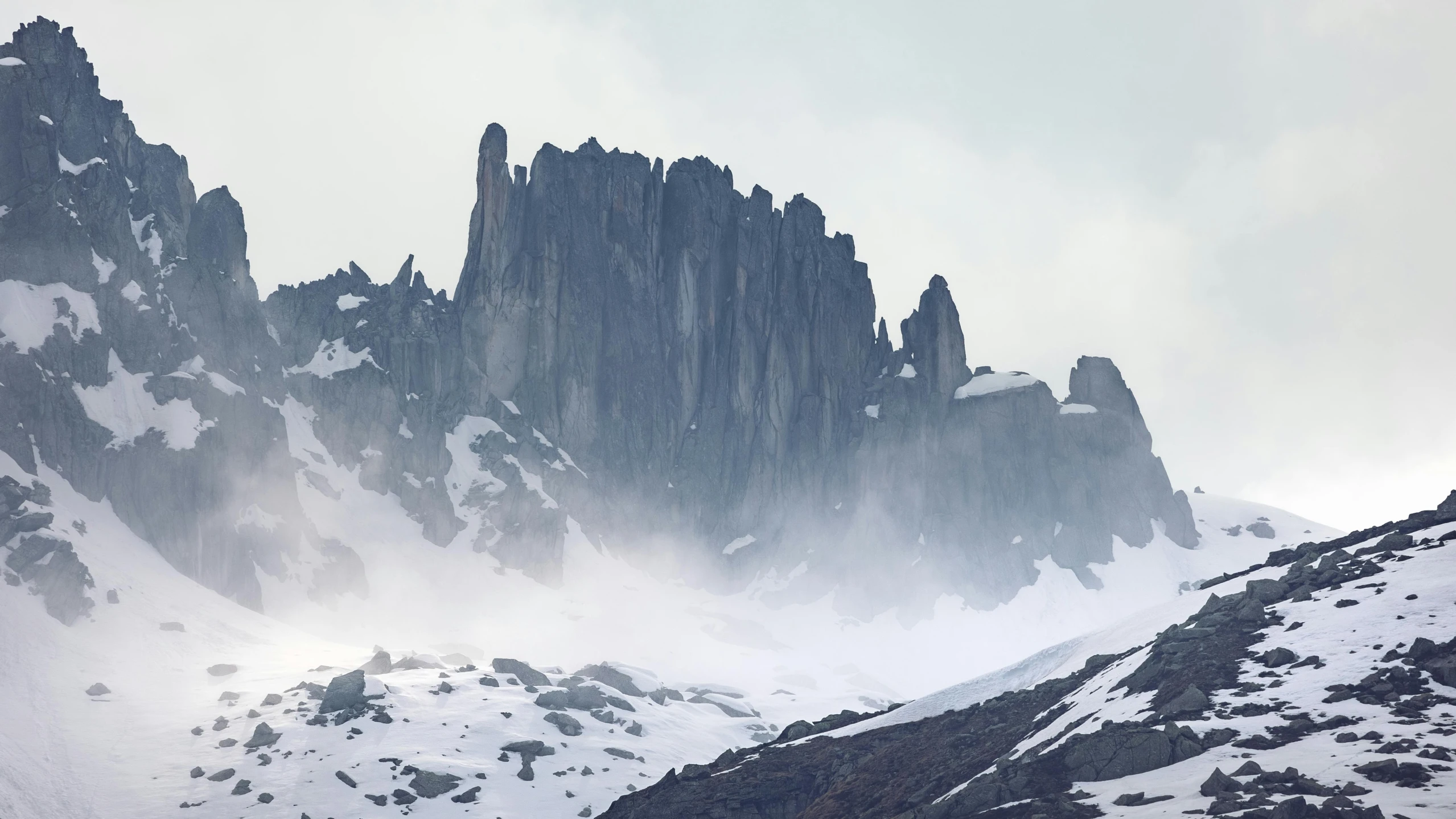 the mountain's rocky side is covered in snow