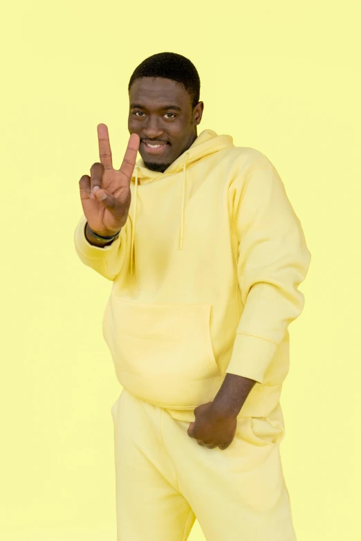 a man wearing yellow is giving the middle finger