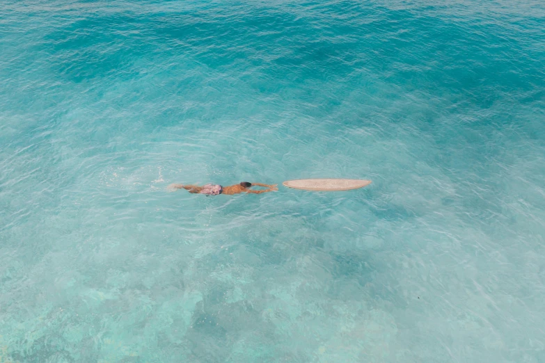 a man floats a board in the ocean near the shore