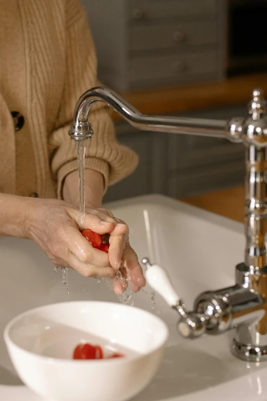 the woman is washing her hands with soap