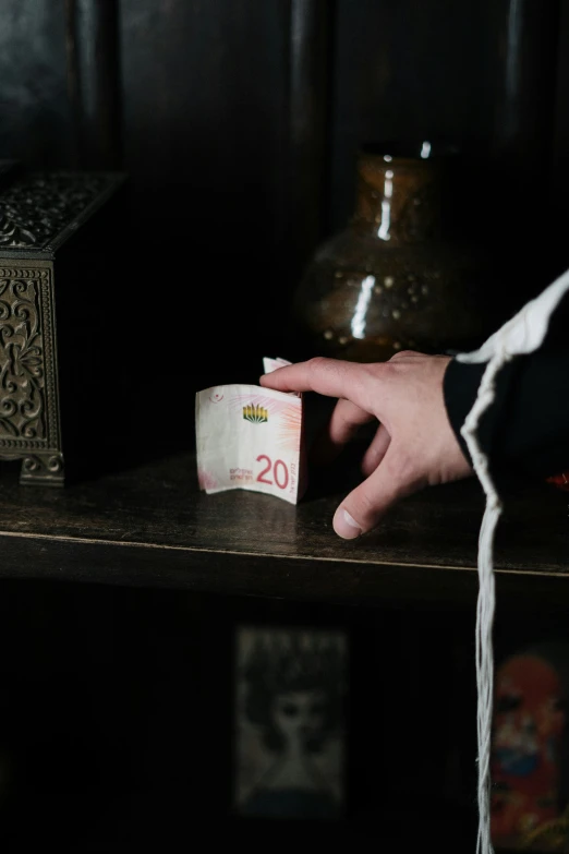 a person using one handed to cut a large roll of money