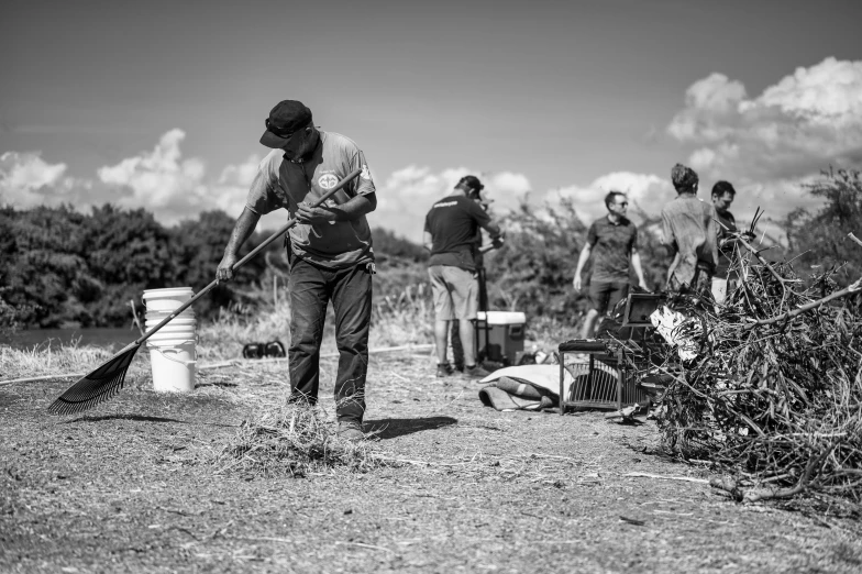 people are collecting the debris in the field with their brooms