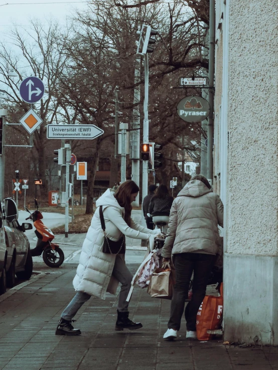 two women in coats hing a bag with their hands