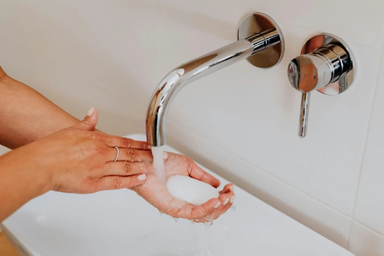 someone washing their hands under the faucet