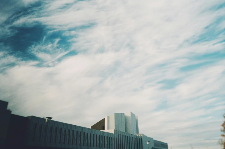 the top portion of a building with lots of clouds