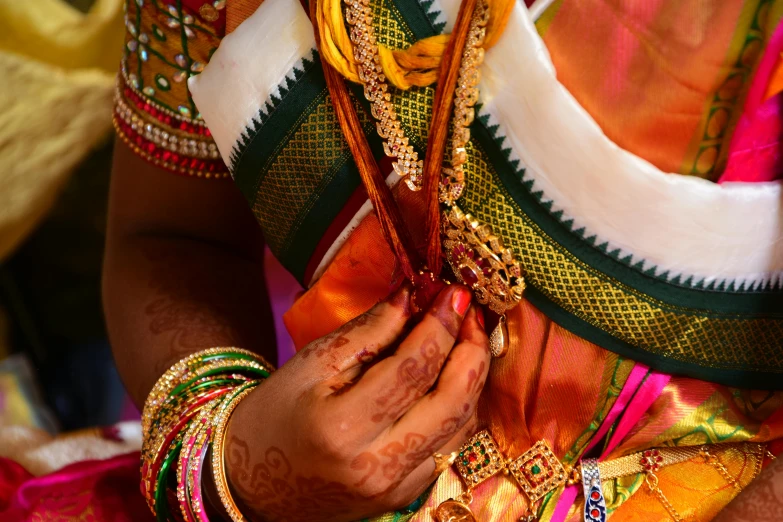 hands tying wedding garbana to traditional wear