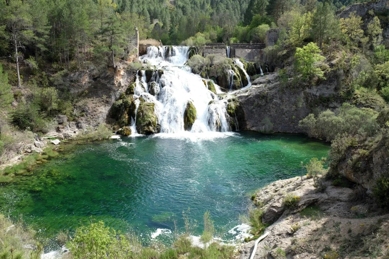 a small waterfall in the middle of some water