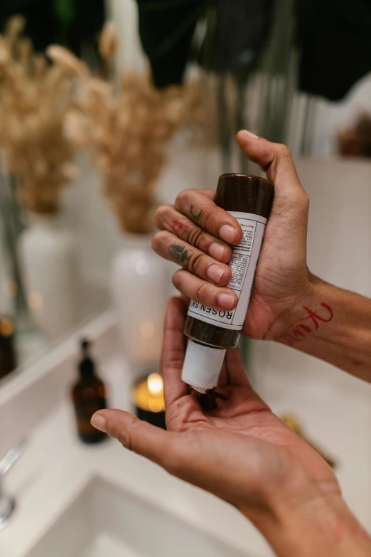 a person is holding out a tube of hand lotion in front of their face