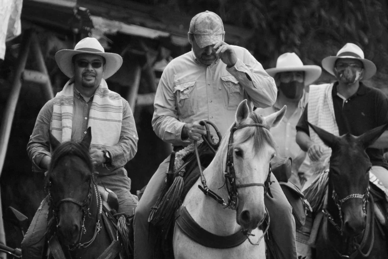 black and white po of four men sitting on horses