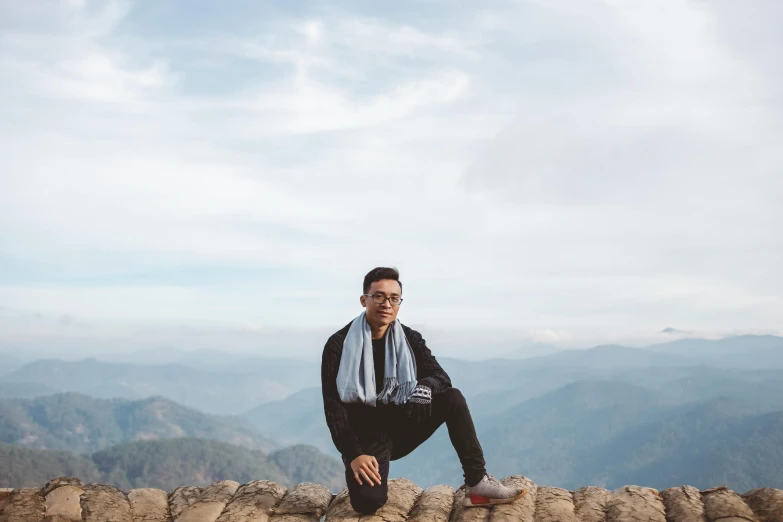 a man crouching on the ground looking at the camera