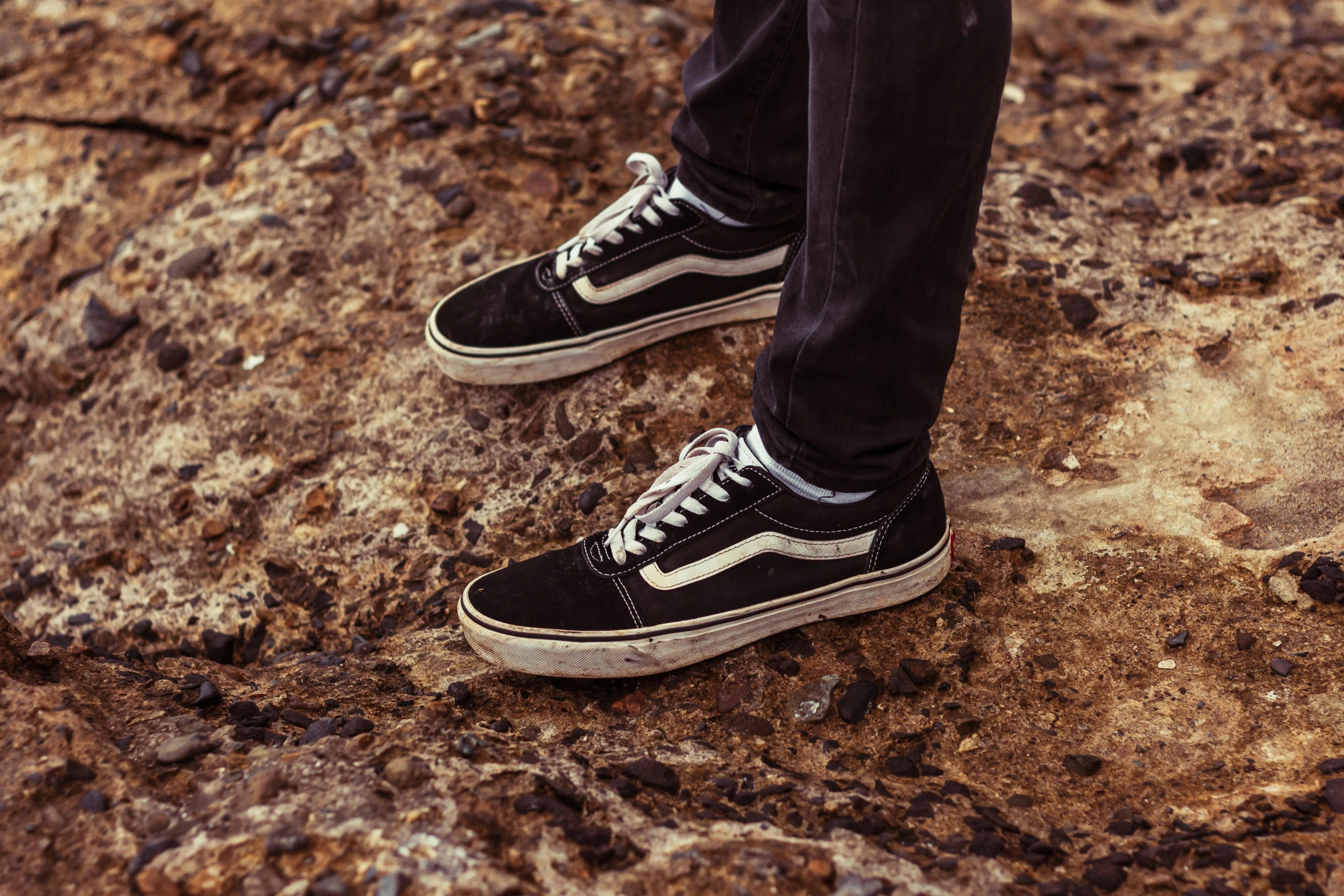 someone standing on the side of the road wearing their black and white shoes