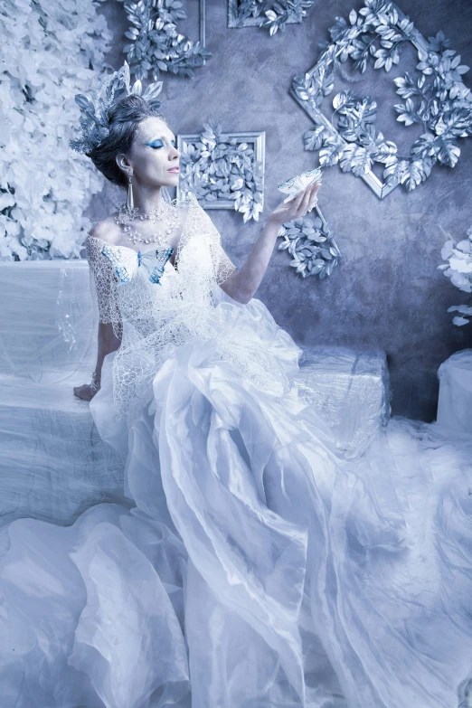 a woman in a white dress poses for a picture with a snowflakes background